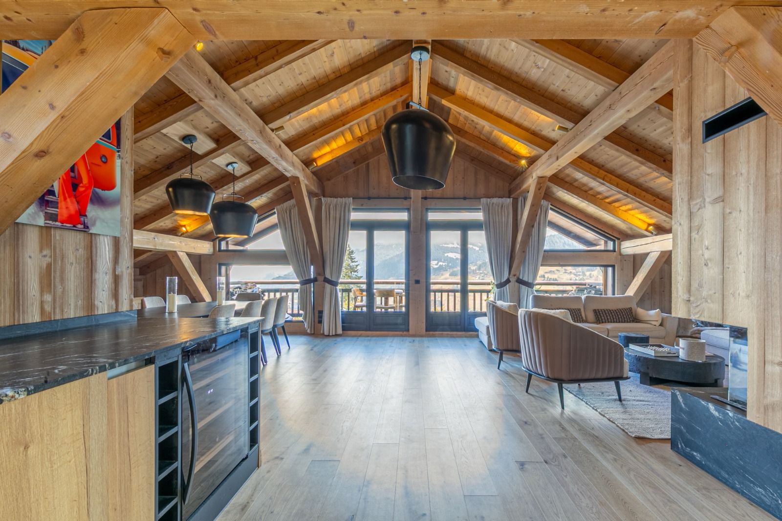 Chalet Megève Un écrin de charme au cœur de Mégève : Rénovation d'un duplex d'exception Niché au sein d'un ancien corps de ferme, ce duplex atypique de 240m² à Mégève offre une expérience de vie unique, où l'authenticité rencontre le confort moderne. La particularité de ce bien réside dans l'agencement de ses espaces de vie : séjour, salon et salle à manger se déploient avec élégance à l'étage, offrant un panorama somptueux sur les montagnes environnantes. Notre mission a été de sublimer ce cadre exceptionnel, en créant un intérieur à la fois chaleureux, accueillant et fonctionnel. Pour capturer et amplifier la beauté du paysage, de grands miroirs ont été stratégiquement placés au-dessus de l'escalier, face à la baie vitrée. Ils agissent comme des fenêtres supplémentaires, inondant l'espace de lumière naturelle et invitant la nature à pénétrer les lieux.