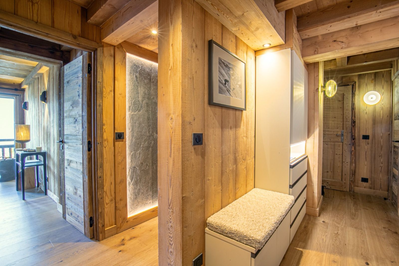Espace nuit La configuration de l'appartement présentait quelques défis, notamment une cuisine de taille modeste et un conduit de cheminée mal positionné. Pour optimiser l'espace et répondre aux besoins d'un bien pouvant accueillir jusqu'à 14 personnes, nous avons imaginé une arrière-cuisine ingénieuse. Discrètement intégrée, elle offre un volume de rangement conséquent, permettant de préserver l'esthétique et la fluidité des pièces de vie principales.